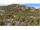 Scenic aerial view showcases home nestled among lush trees with mountain views at 25531 Mosier Cir, Conifer, CO 80433