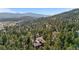 Serene aerial view of a house nestled among trees with mountains in the background at 25531 Mosier Cir, Conifer, CO 80433