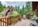 Enjoy outdoor dining on a spacious wooden deck with large boulders and lush forest views at 25531 Mosier Cir, Conifer, CO 80433