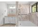 Bright bathroom featuring a shower with marble-look tile and a white vanity with a gold countertop at 25531 Mosier Cir, Conifer, CO 80433