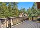 Large deck with wood railing showcasing a view of the trees and rock formations at 25531 Mosier Cir, Conifer, CO 80433