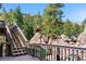 Multi-level wood deck with flower pots and railing, with beautiful mountain rock formations and trees in the distance at 25531 Mosier Cir, Conifer, CO 80433