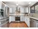 Bright kitchen featuring white cabinets, stainless steel appliances, and a decorative backsplash at 25531 Mosier Cir, Conifer, CO 80433