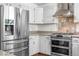 Modern kitchen featuring stainless steel refrigerator and range with decorative tile backsplash at 25531 Mosier Cir, Conifer, CO 80433