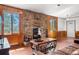 Cozy living room with a stone fireplace, wood floors, and a large window with a view to the outdoors at 25531 Mosier Cir, Conifer, CO 80433