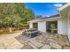 Backyard with stone patio, outdoor seating area and lush green landscaping surrounded by mature trees at 6668 Walker Ct, Niwot, CO 80503