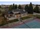 Beautiful home with tennis court, stone patio, lush lawn, and mature trees at 6668 Walker Ct, Niwot, CO 80503