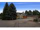 Exterior view of a home featuring a three-car garage, surrounded by lush greenery and mature trees at 6668 Walker Ct, Niwot, CO 80503