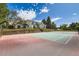Full backyard tennis court with a basketball hoop, surrounded by lush trees and beautiful landscaping at 6668 Walker Ct, Niwot, CO 80503