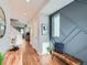 Inviting hallway with modern accents, decorative wall paneling, and warm wood floors at 4723 Crestone Peak St, Brighton, CO 80601