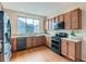 Well-lit kitchen with wood cabinets, stainless steel appliances, and large window above sink at 4723 Crestone Peak St, Brighton, CO 80601