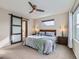 Comfortable bedroom featuring a ceiling fan, stylish sliding barn door and an en suite bathroom at 4723 Crestone Peak St, Brighton, CO 80601