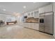 Basement bar area with white cabinetry, stainless steel appliances, and an adjacent game room with a pool table at 13955 Craig Way, Broomfield, CO 80020