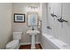 A minimalist powder room with a pedestal sink, decorative climbing men art, and unique light fixture at 13955 Craig Way, Broomfield, CO 80020