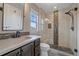 Charming bathroom featuring stone floors, a glass shower with bench, and dark wood cabinets at 13955 Craig Way, Broomfield, CO 80020