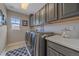 Efficient laundry room with gray cabinets, modern washer and dryer, and a window at 13955 Craig Way, Broomfield, CO 80020