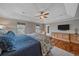 Bright main bedroom with a tray ceiling, hardwood floors, and a wall-mounted television at 13955 Craig Way, Broomfield, CO 80020