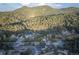 Panoramic aerial view showcases a property surrounded by lush greenery and winding roads in a mountain community at 5077 Camel Heights Rd # C, Evergreen, CO 80433