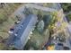 Overhead view of apartment building with parking, surrounded by mature trees and landscaping in a serene setting at 5077 Camel Heights Rd # C, Evergreen, CO 80433