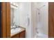 Bright bathroom features a shower with white tiling, neutral walls, and a wood vanity at 5077 Camel Heights Rd # C, Evergreen, CO 80433