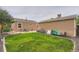 Spacious backyard with a patio area, lawn, and mature landscaping at 6736 Grove St, Denver, CO 80221
