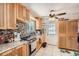 Well-lit kitchen with wooden cabinets, mosaic backsplash, and stainless steel appliances at 6736 Grove St, Denver, CO 80221