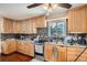 Functional kitchen featuring wood cabinets, modern appliances, and tile flooring at 6736 Grove St, Denver, CO 80221