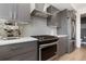 Close-up of a modern kitchen with stainless steel appliances, gray cabinets, and subway tile backsplash at 2851 W 23Rd Ave # 1, Denver, CO 80211