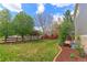Spacious backyard featuring a lush lawn, bordered by mulch, mature trees, and a classic wood fence at 2901 Madison Ln, Broomfield, CO 80023