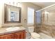 Tiled bathroom featuring a glass door shower and a mirror with a dark wooden frame at 2901 Madison Ln, Broomfield, CO 80023