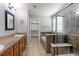 A bathroom with a long countertop, dual sinks, separate tub and glass shower, and a walk-in closet at 2901 Madison Ln, Broomfield, CO 80023