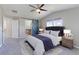 Bedroom with a large bed, fan, and a blue sliding door leading to a bathroom at 2901 Madison Ln, Broomfield, CO 80023