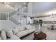 Open-concept living room with a staircase, view into the kitchen, and neutral colored furnishings at 2901 Madison Ln, Broomfield, CO 80023