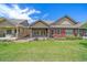 A well-maintained backyard with a lush lawn, patio, and landscaped garden beds that adjoin the house at 1130 Summit View Dr, Louisville, CO 80027