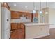 Bright kitchen boasts stainless appliances, stone counters, wood cabinets, hardwood floors and center island at 1130 Summit View Dr, Louisville, CO 80027