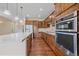 Open kitchen features granite counters, a kitchen island, stainless steel appliances, and beautiful wood floors at 1130 Summit View Dr, Louisville, CO 80027