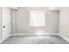 Unfinished basement featuring neutral carpet, a window, and a white door at 3328 S Danube St, Aurora, CO 80013