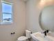 Modern half bathroom with white vanity, oval mirror, and natural light from the window at 4748 Weitbrec Ln, Castle Rock, CO 80104