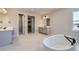Main bathroom featuring a soaking tub, walk in closet, and double vanity at 4748 Weitbrec Ln, Castle Rock, CO 80104