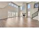 Expansive living room with a stone fireplace, high ceilings, hardwood floors, and sliding doors at 4748 Weitbrec Ln, Castle Rock, CO 80104