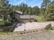 Aerial shot of a home with an extended driveway and basketball hoop surrounded by trees and landscaped areas at 35550 Running Brook Ln, Elizabeth, CO 80107