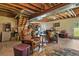 Basement featuring exposed ceiling beams, concrete floor, exposed ductwork, and comfortable seating around a table at 35550 Running Brook Ln, Elizabeth, CO 80107