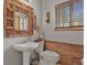 Charming powder room with unique mirror, decorative wood accents, and natural light from the window at 35550 Running Brook Ln, Elizabeth, CO 80107