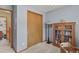 Light blue bedroom with natural wood accents, neutral carpet, a full bookcase, and an ensuite bathroom at 35550 Running Brook Ln, Elizabeth, CO 80107