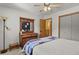 Light-filled bedroom with a decorative dresser, a large mirror, neutral walls, and a glimpse of the upstairs hallway at 35550 Running Brook Ln, Elizabeth, CO 80107