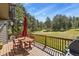 Inviting outdoor deck with wooden furniture, a grill, and picturesque views of the surrounding trees and landscape at 35550 Running Brook Ln, Elizabeth, CO 80107