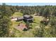 Aerial shot showing a large home with an attached garage and a beautifully landscaped yard in a wooded setting at 35550 Running Brook Ln, Elizabeth, CO 80107