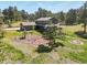 Aerial view showcasing a home with a lush green lawn, mature trees, and beautifully landscaped gardens at 35550 Running Brook Ln, Elizabeth, CO 80107