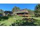 Inviting two-story home with a spacious wooden deck, surrounded by a well-maintained lawn and mature trees at 35550 Running Brook Ln, Elizabeth, CO 80107