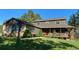 Charming two-story home featuring a welcoming front porch, lush lawn, and mature trees, creating a serene curb appeal at 35550 Running Brook Ln, Elizabeth, CO 80107